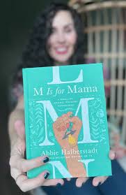woman holding M Is For Mama Book