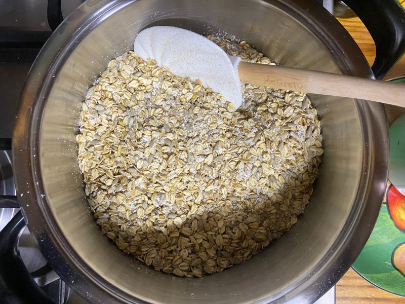 the best granola in only 20 min on the stovetop, second step, oats, sunflower seeds and desiccated coconut stirred in a pot