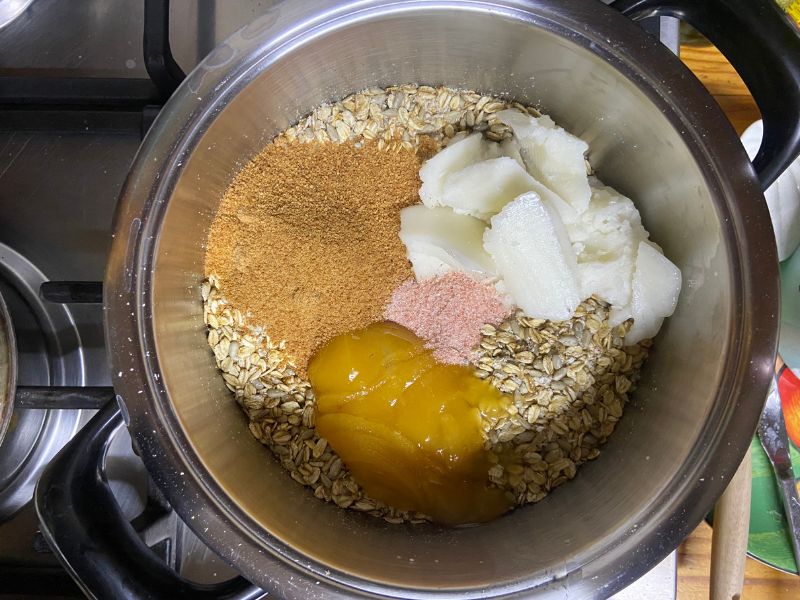 dry mixture of oats, sunflower seeds and desiccated coconut with coconut oil, honey, coconut sugar and salt added