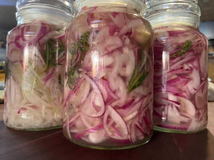 Sweet and sour pickled onions in glass jars